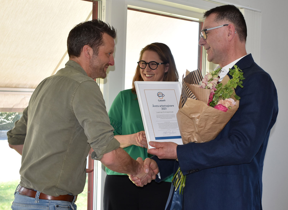 Leeman Entreprenads vd och hr uppvaktas med blommor och diplom